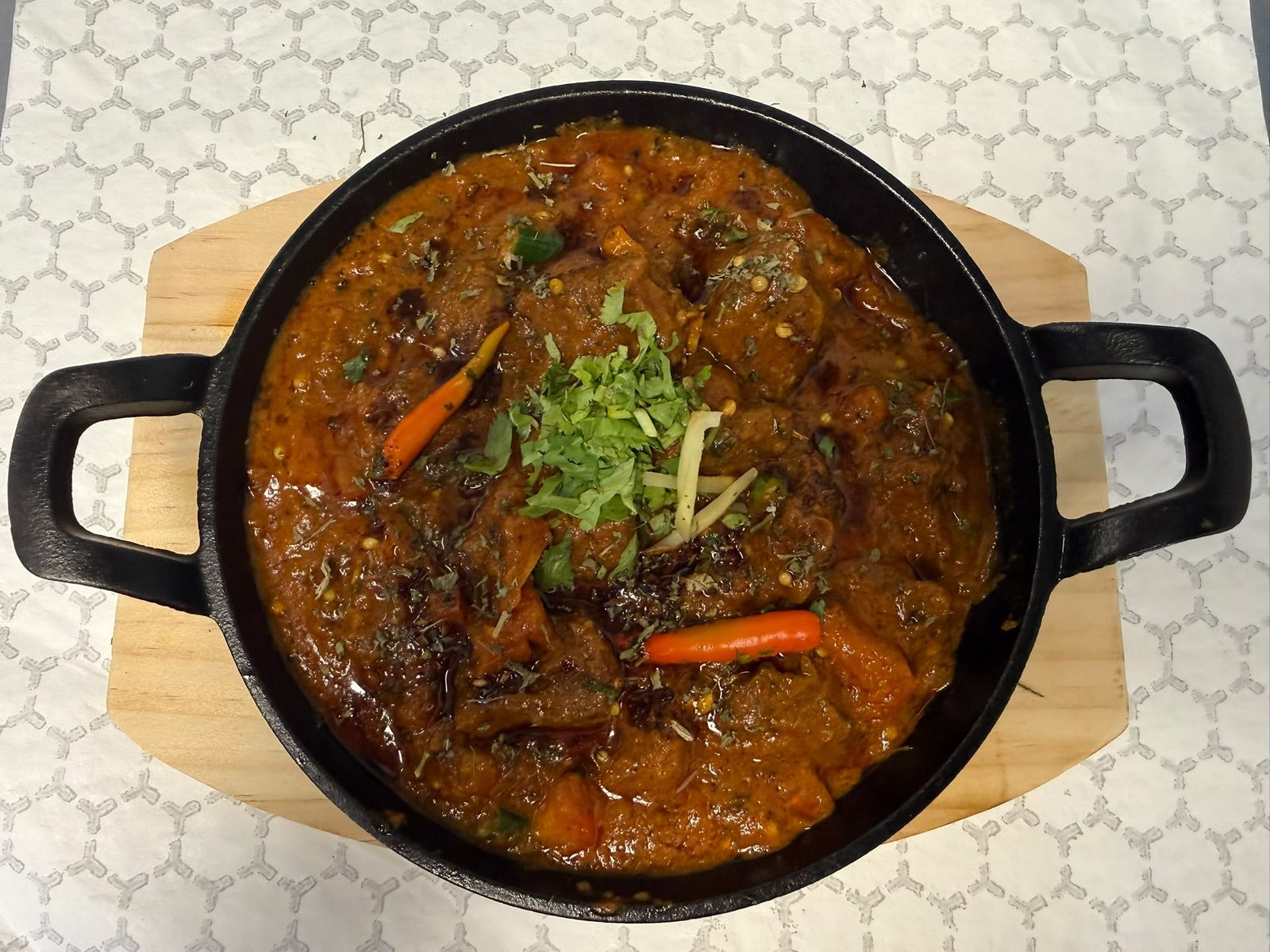 Lamb karahi, slow-cooked on the bone with dried red chilli and ginger, served whole in a cast-iron karahi